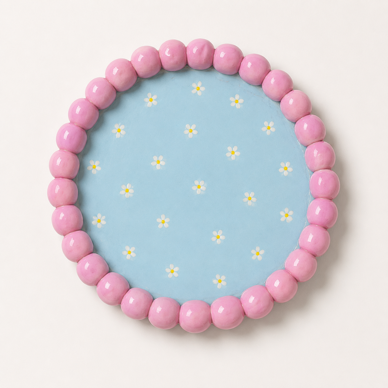 Round beaded tray in blue and pink tones.